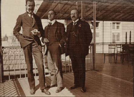 Eugen Wachenheimer as a young man with two unknown men outside under a canopy, 1906-1926,