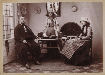 Portrait of an unknown man and two unknown women in traditional costumes from Hindeloopen,