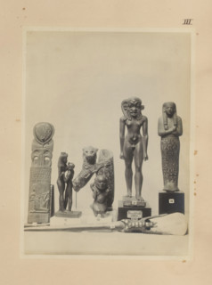 Seven Egyptian objects, including a bronze sculpture of Isis with Horus, a bronze sculpture of