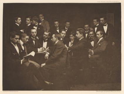 Group of men in suits, including one with a book in hand, page, photomechanical print,