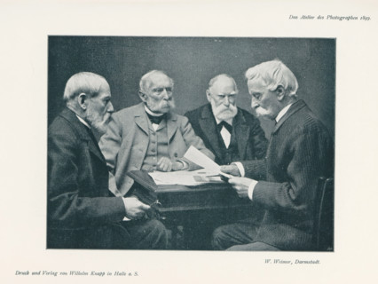Four men at a table, page, photomechanical print, inscription: 'Das Atelier des Photographen.',