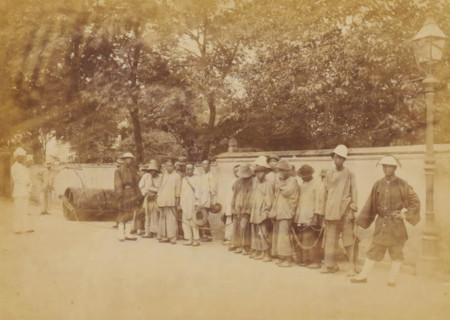 Group of Chinese people chained together under the supervision of guards, The chain-gang,