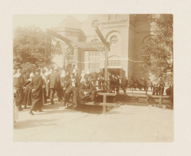 Churchgoers in Volendam, photograph, Men and women in traditional costume cross the drawbridge to