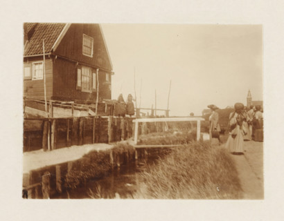 Marken, photograph, Tourists view houses in Marken; two women in traditional costume stand in front