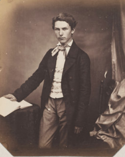 Portrait of an unknown standing young man with hand on book, photograph, photographer: attributed