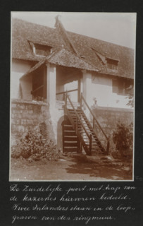 The southern gate with stairs of the barracks mentioned above. Two natives are standing in the