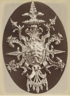 Decorative lead shield with a lion's head and leaf motifs, Cartonche en plomb repoussé an marteau,