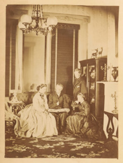 Two men and two women look at a photo album in a living room, photograph, page, photographer: JC