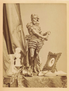 Bronze sculpture, photo frame, pipe and other items on a table, photograph, page, photographer: