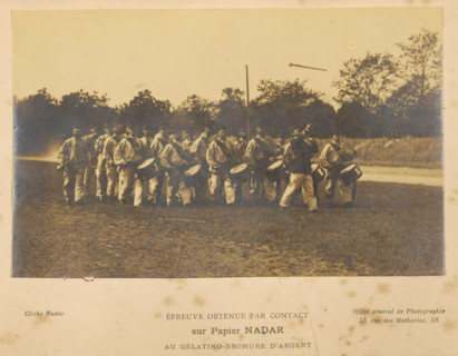 View of a group of unknown men with, among other things, drums, photograph, page, inscription: