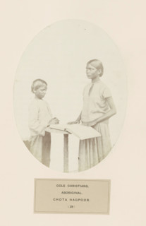 Praying boy and a girl with a book behind a desk from Chota Nagpur in eastern India, photograph,