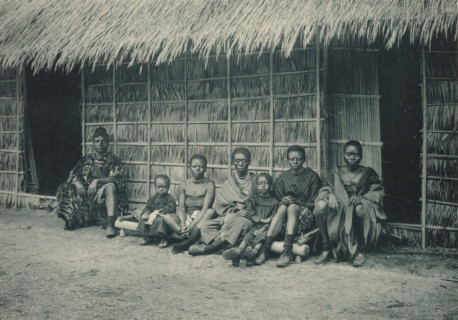 A family sits in front of a house in a recreated Congolese village at the Antwerp World Exhibition