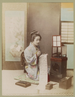 Woman writes a letter in an interior, photograph, page, photographer: attributed to Kusakabe
