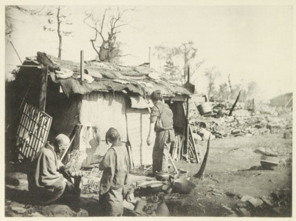 Two women and a man in front of a temporary home in Japan, page, photomechanical print, Japan,