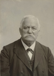 Portrait of an older man with a mustache, in dark clothing, photograph, in dark clothing.,