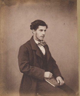 Portrait of an unknown seated young man with a checkered bow tie, with a book in his hand,