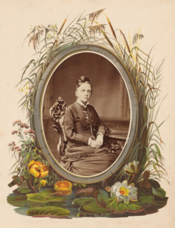 Portrait of a woman sitting on a chair at a table on which an album lies, photograph, cabinet