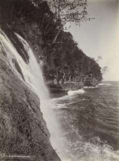 Coast of the Dutch East Indies with waterfall flowing into the sea, photograph, Part of Travel