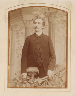 Portrait of a young man, standing by a stair railing, album page, photograph, cabinet photograph,