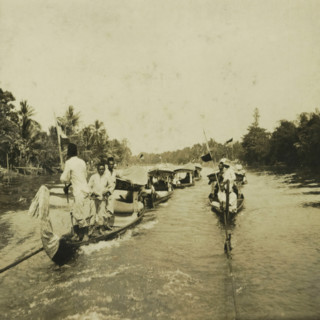 Some boats on the Sungai Martapura river, with both Europeans and original inhabitants of Borneo,