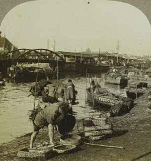 People and boats along a river in Yokohama, A glimpse of the busy river life. Yokohama, Japan,
