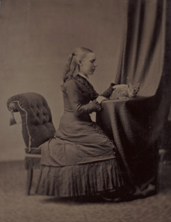 Portrait of an unknown young woman sitting at a table with a cat, photograph, 1855 - 1900,