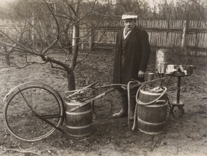 Man by a self-built pesticide spraying system for fruit trees, possibly in Denmark, photograph,