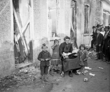 A poor Belgian woman outside her burnt out home in Melle with her four children