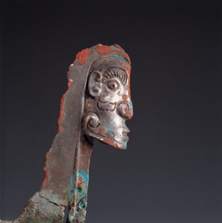 Sculpture en forme de visage sur une hallebarde en bronzer