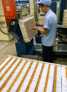 A worker makes cigarette in the workshop of Zhengzhou Tobacco Factory in Henan, China