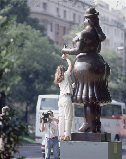 BOTERO FERNANDO 1932
MUJER - TURISTAS CON CAMARA DE VIDEO GRABANDOSE ENCIMA DE LA