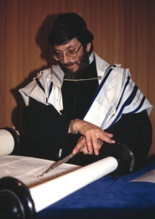 A rabbi reads from the torah in the synagogue