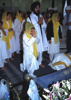 People pay their respects before the Guru Granth Sahib