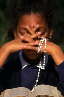 Rosary beads, a woman saying the rosary