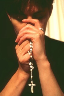 Woman praying the rosary beads