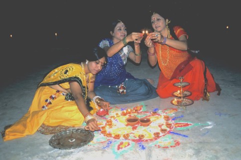 HIndu women designing a rangoil for Divali Festival of Lights India