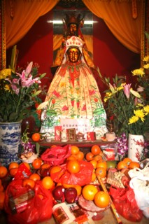 Chinese Goddess of Merchy Kuan Yin with new year offerings Hongkong
