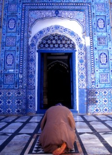 Man prays in front of the qiblah or prayer niche