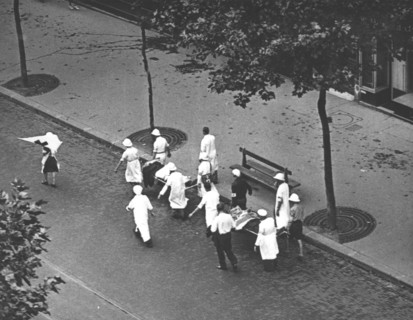 Groupe de brancardiers de la Croix-Rouge transportant deux blessés, lors de l'insurrection de Paris (août 1944)