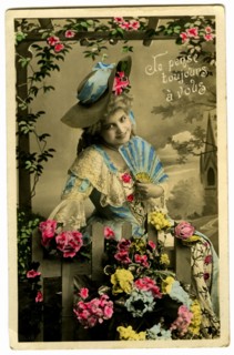 Carte postale représentant une femme posant parmi des fleurs