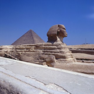 Sphinx of the Giza plateau, view towards the pyramid of Cheops