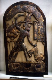 Stèle représentant le roi guidé par le faucon en position de massacre d'un fauve saisi par la queue