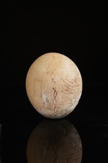 Oeuf d'autruche peint en rouge de croisillons et de méandres