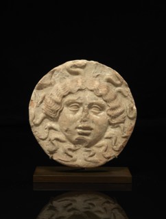Antéfixe circulaire représentant le visage de face de Méduse