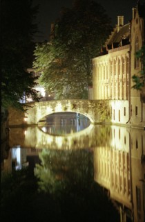 Bruges de nuit : maisons sur le canal, pont et quai, reflets dans le canal, en automne