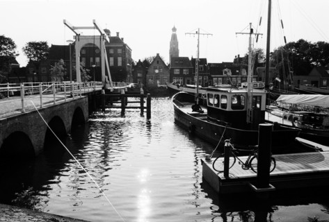 Canal d'Enkhuizen en contre-jour, avec un pont levant et des bateaux amarrés. Enkhuizen, Pays-Bas