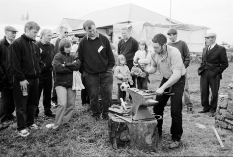 Spectators gathered around a man at work at the Riverstown country fair. County Sligo, Ireland