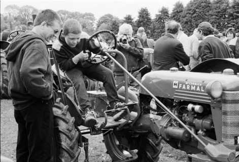 Garçon assis sur un tracteur ancien, lors de la foire rurale de Riverstown. Comté de Sligo, Irlande