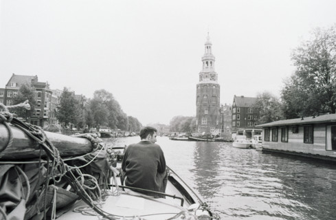 La Munttoren vue depuis un canal, une personne assise à l'avant d'un bateau. Amsterdam, Pays-Bas
