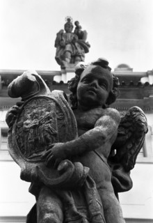 Statue d'un putto tenant un bouclier orné d'un emblème, vue en contre-plongée. Prague, République